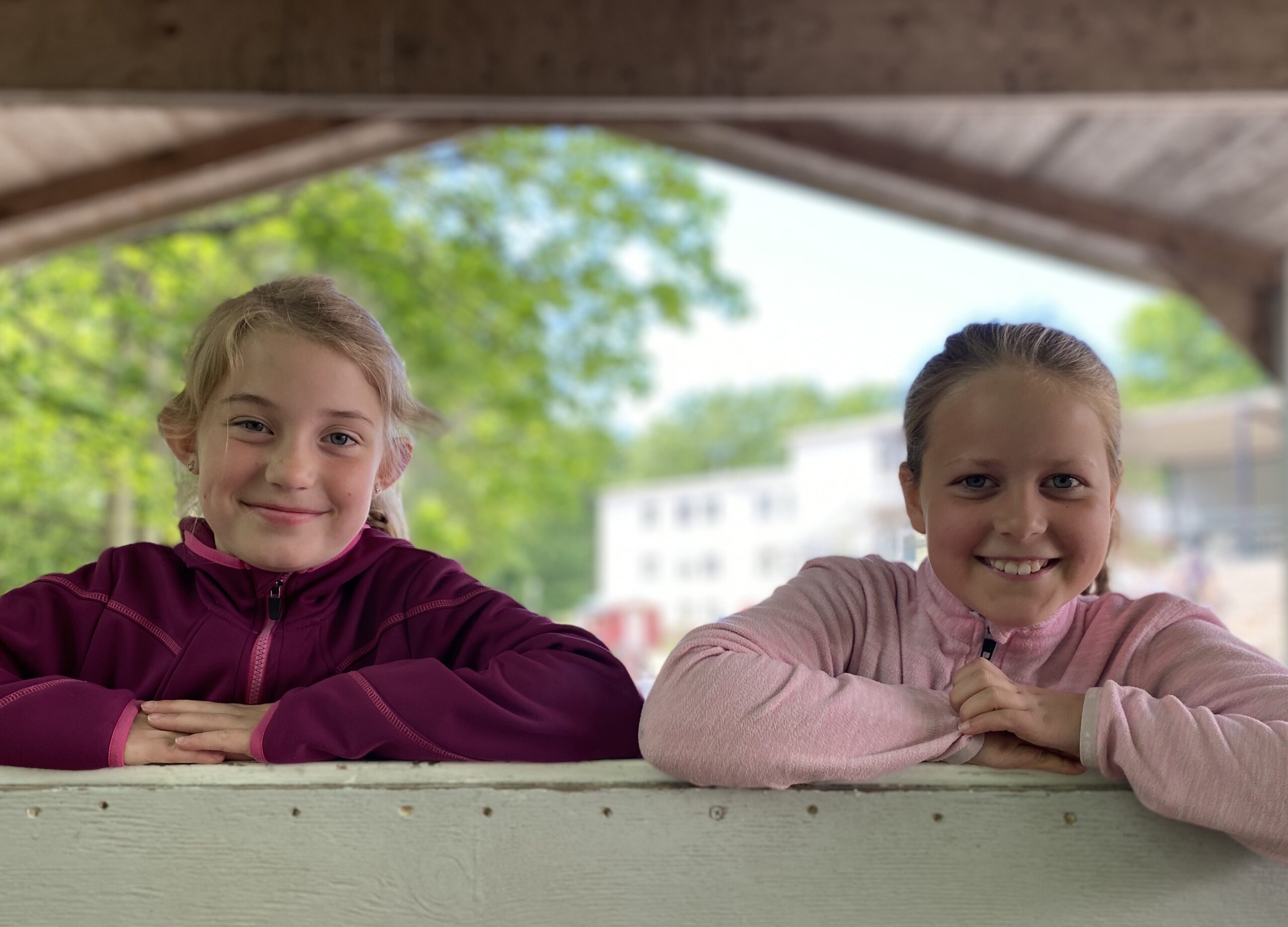Två flickor på lekplats utanför skolbyggnad